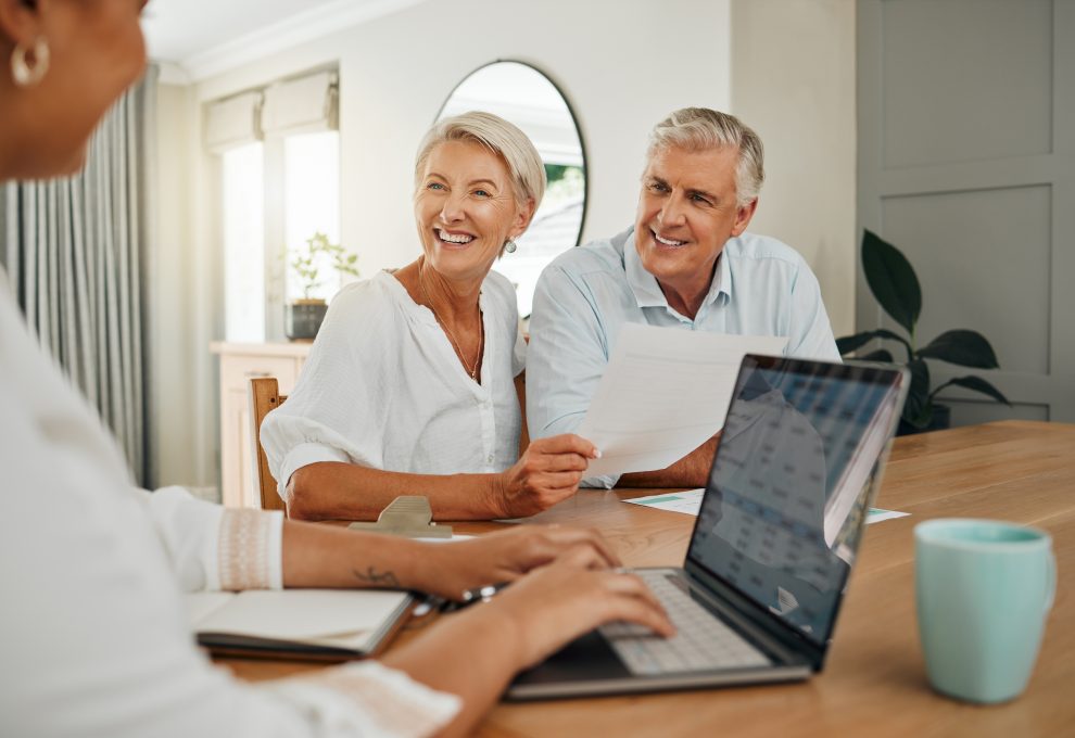 Retirement, savings and couple planning finance, insurance and investments in living room. Man and woman and seniors communication, talking and discuss wealth with internet banking and laptop at home.