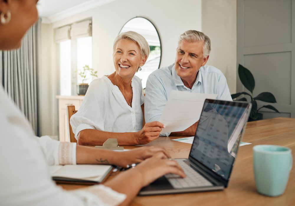 Retirement, savings and couple planning finance, insurance and investments in living room. Man and woman and seniors communication, talking and discuss wealth with internet banking and laptop at home.