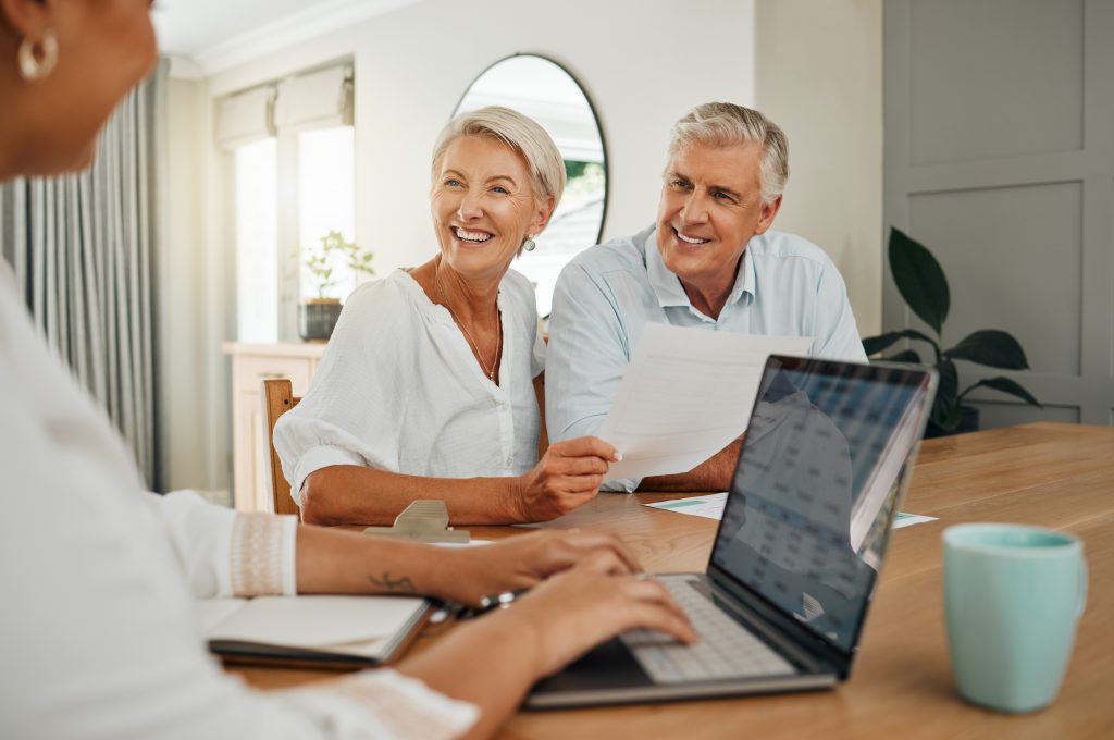 Retirement, savings and couple planning finance, insurance and investments in living room. Man and woman and seniors communication, talking and discuss wealth with internet banking and laptop at home.